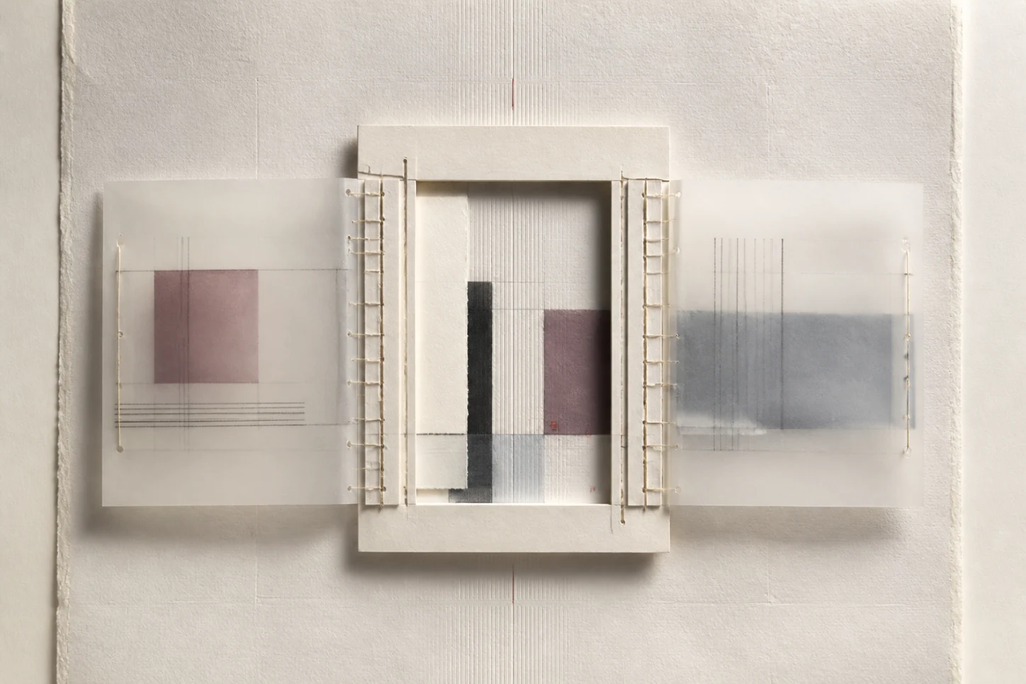 An architectural paper frame with interchangeable translucent panels attached by visible stitched boundaries